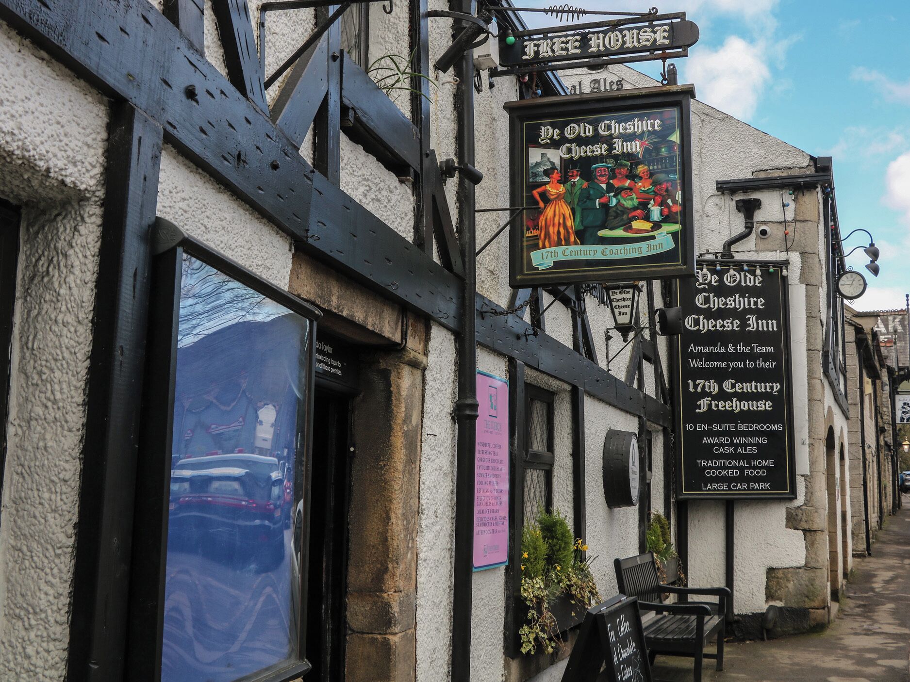 A traditional 17th-century coaching inn with a signboard advertising free house, cask ales, and a large car park.