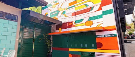 A colorful building with a green door and a sign that reads "JUNECO MARCOS".