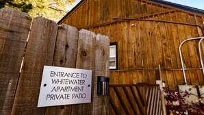 A wooden fence with a sign indicating entrance to a private patio.