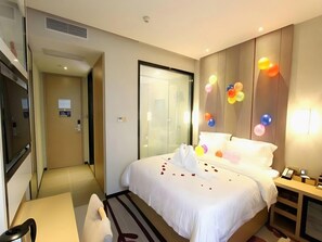 A hotel room with a bed, bedside table, and a mirror. There is a door leading to another room. - Lavande Hotel Shenzhen University city Metro Station (Shenzhen)