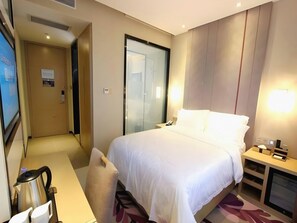 A hotel room with a bed, bedside table, desk, chair, and a television. - Lavande Hotel Shenzhen University city Metro Station (Shenzhen)