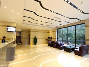 A modern hotel lobby with a reception desk, seating area, and large windows offering a view of the outdoors. - Lavande Hotel Shenzhen University city Metro Station (Shenzhen)