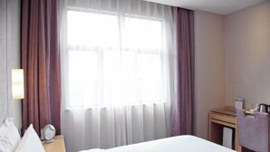 A hotel room with a bed, a desk, a chair, a lamp, and a window with curtains. - Lavande Hotel Shenzhen University city Metro Station (Shenzhen)