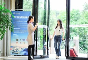 A person standing by a glass door with a poster on the wall. - Lavande Hotel Shenzhen University city Metro Station (Shenzhen)