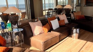 Una sala de estar moderna con sofás de cuero, una mesa de centro y vistas al mar.