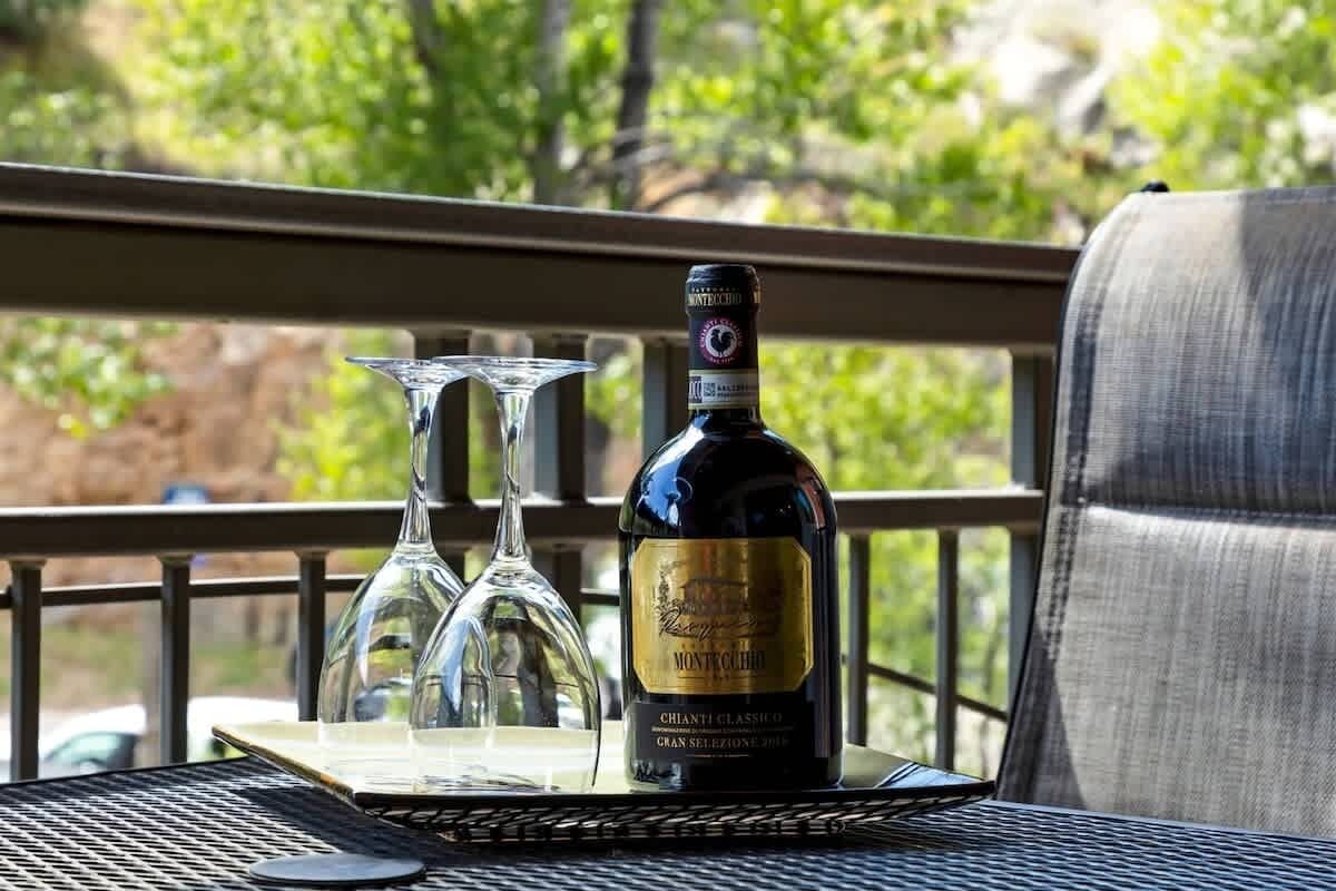 A bottle of Montecucco Chianti Classico on a table with two wine glasses.