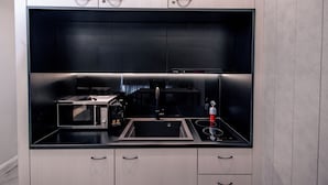 A modern kitchen with a built-in microwave, sink, and stove.