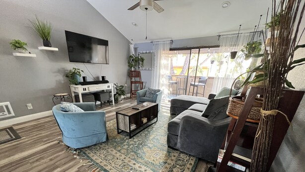 A modern living room with a sofa, armchair, coffee table, and a TV mounted on the wall. - COZY UCSD/La Jolla Condo 2bd, 10-15 min from just about anywhere in the city (San Diego)