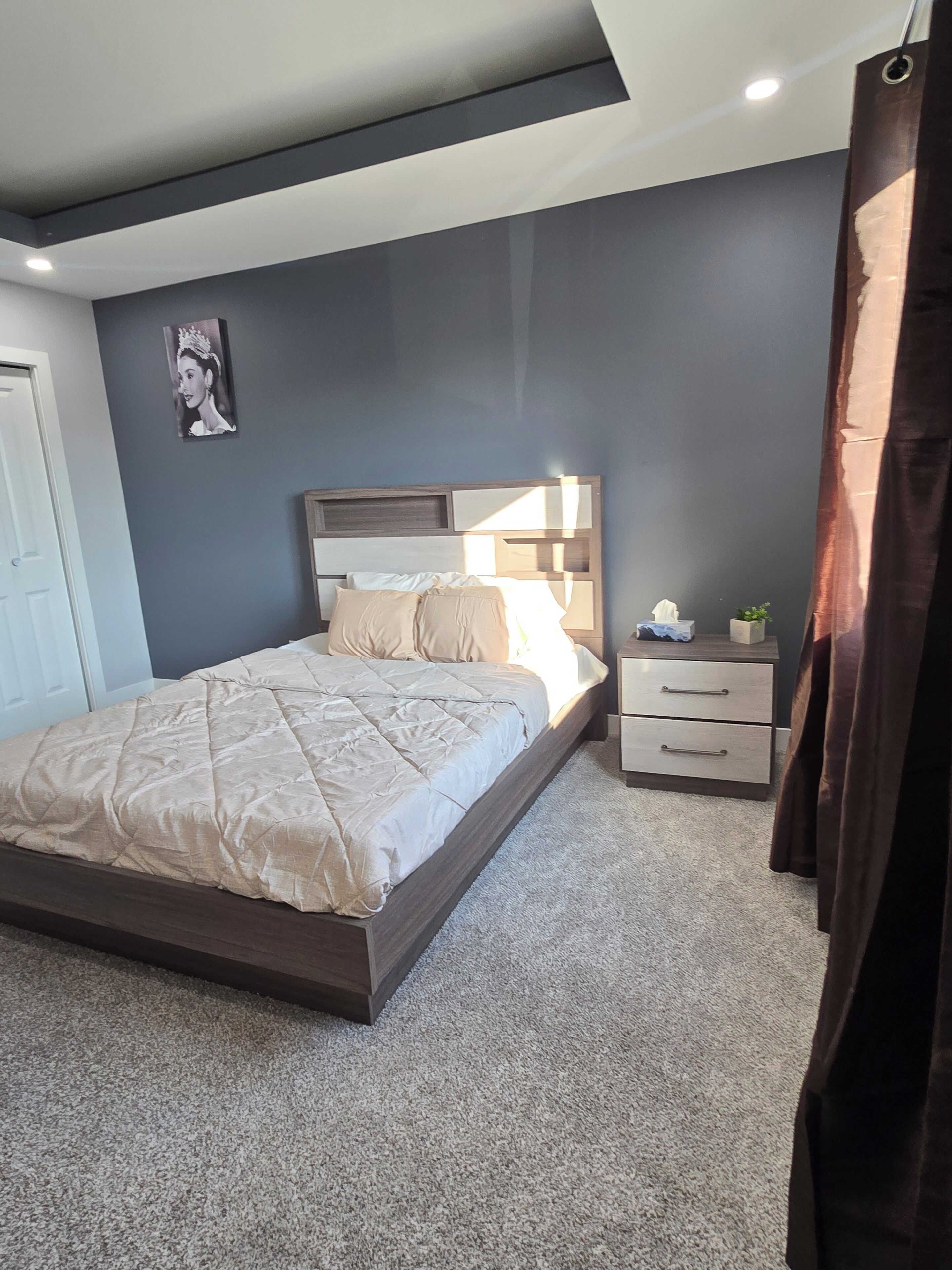 A bedroom with a bed, bedside table, and a nightstand.