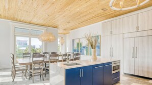 Una cucina moderna con soffitto in legno, pensili blu e una grande isola.