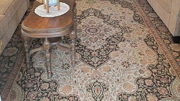 A cozy living room with two sofas, a coffee table, and a patterned rug. A kitchen is visible in the background. - 2 BR Entire Peaceful Home  (Trion)