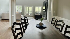 A dining area with a long table, black chairs, and a central decorative piece. - Secluded Cove and Dock at Tim's Ford (Winchester)