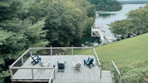 A wooden deck with outdoor seating and a view of a lake surrounded by trees. - Secluded Cove and Dock at Tim's Ford (Winchester)