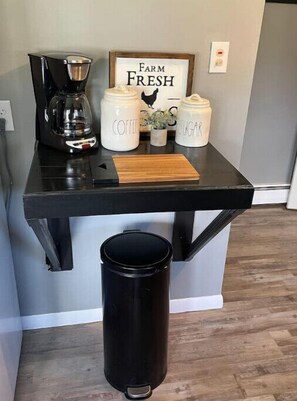 Enjoy a homey kitchen with a coffee maker, coffee and sugar jars, and a 'Farm Fresh' sign.
