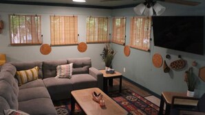 A living room with a sectional sofa, a coffee table, and a television mounted on the wall. - Gidget at Villager- Pool,Resort Dock (Burnside)