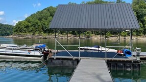 A dock with a covered seating area and boats. - Gidget at Villager- Pool,Resort Dock (Burnside)
