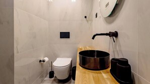 Une salle de bain moderne avec des toilettes, un lavabo et un grand miroir.