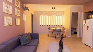Un salon moderne comprenant un canapé, une sculpture décorative et un coin repas avec une table et des chaises.