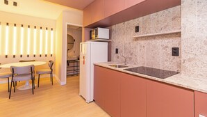 Une cuisine moderne dotée d’un plan de travail en marbre, d’un évier encastré et d’un réfrigérateur.