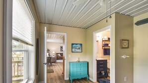 Ein Schlafzimmer mit einem Bett, einer turquoise Kommode und einem Flur, der zu einem Badezimmer führt.