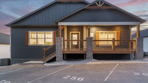 A two-story building with a covered porch and a garage. - Timeless Lake Views, Indoor Pool, Game Room, Hot tub, Firepit, Minutes from SDC (Branson)