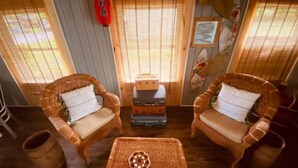 A room with two wicker chairs, a small table, and a wooden cabinet. - Kellerman’s at Villager-Pool, Resort Dock (Somerset)