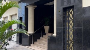 A building entrance with a sign reading "IRAPUAN," a staircase leading to the entrance, and a decorative door with geometric patterns. - Side View of the sea 2 Minutes From the Beach Fms601 (Rio de Janeiro)