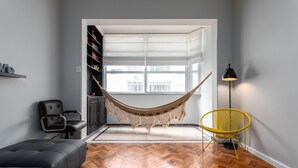 A modern living room with a hammock, a yellow chair, a black lamp, and a grey sofa. - Side View of the sea 2 Minutes From the Beach Fms601 (Rio de Janeiro)
