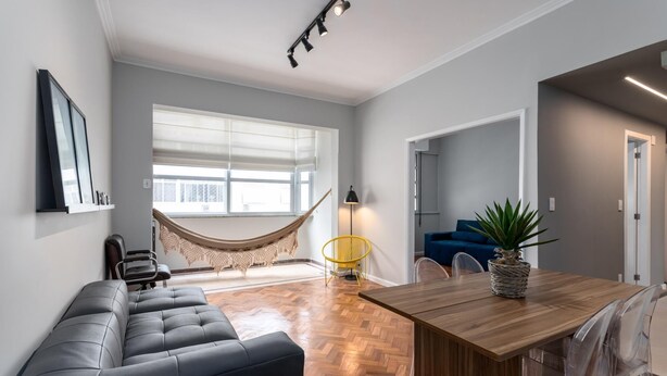 A modern living room with a sofa, a dining table, a hammock, and a potted plant. - Side View of the sea 2 Minutes From the Beach Fms601 (Rio de Janeiro)