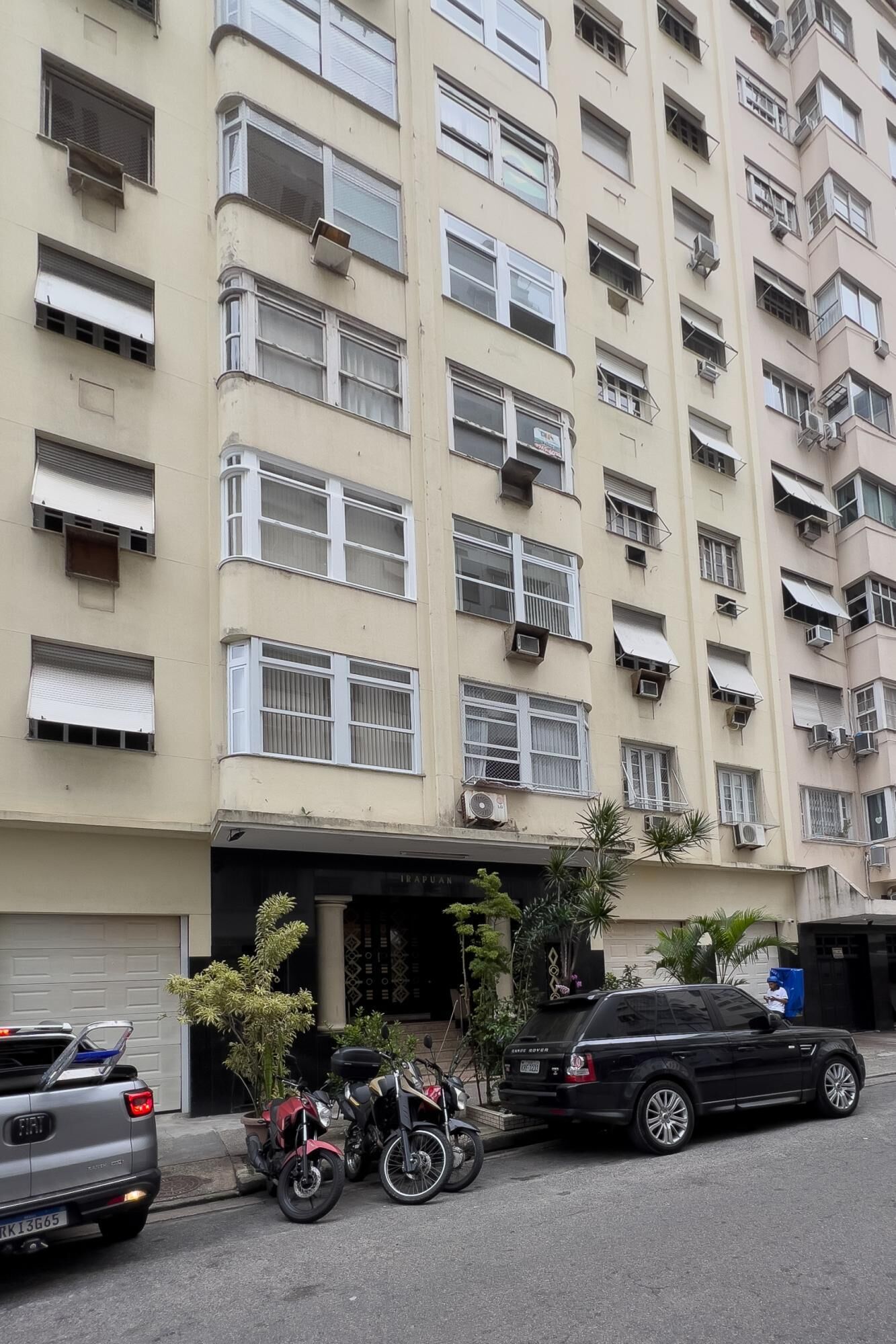 A multi-story building with balconies and air conditioning units.