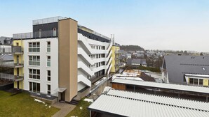 A multi-story residential building with balconies, a flat roof, and a view of surrounding houses. - GebirgsResort Winterberg (Winterberg)