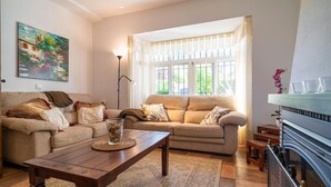 A living room with a sofa, coffee table, and a fireplace.