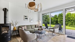 Una sala de estar moderna con un sofá, sillones, una mesa de centro y una chimenea.