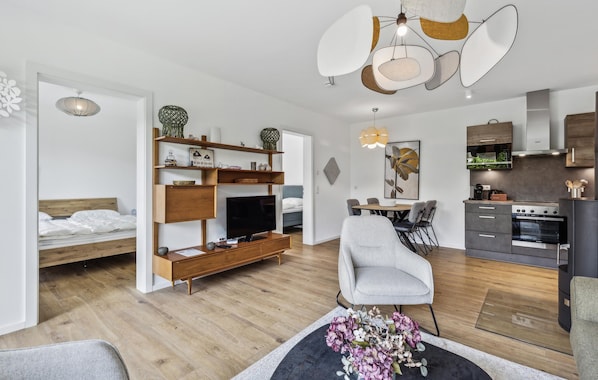 Un apartamento moderno con sala de estar, comedor, cocina y un dormitorio.