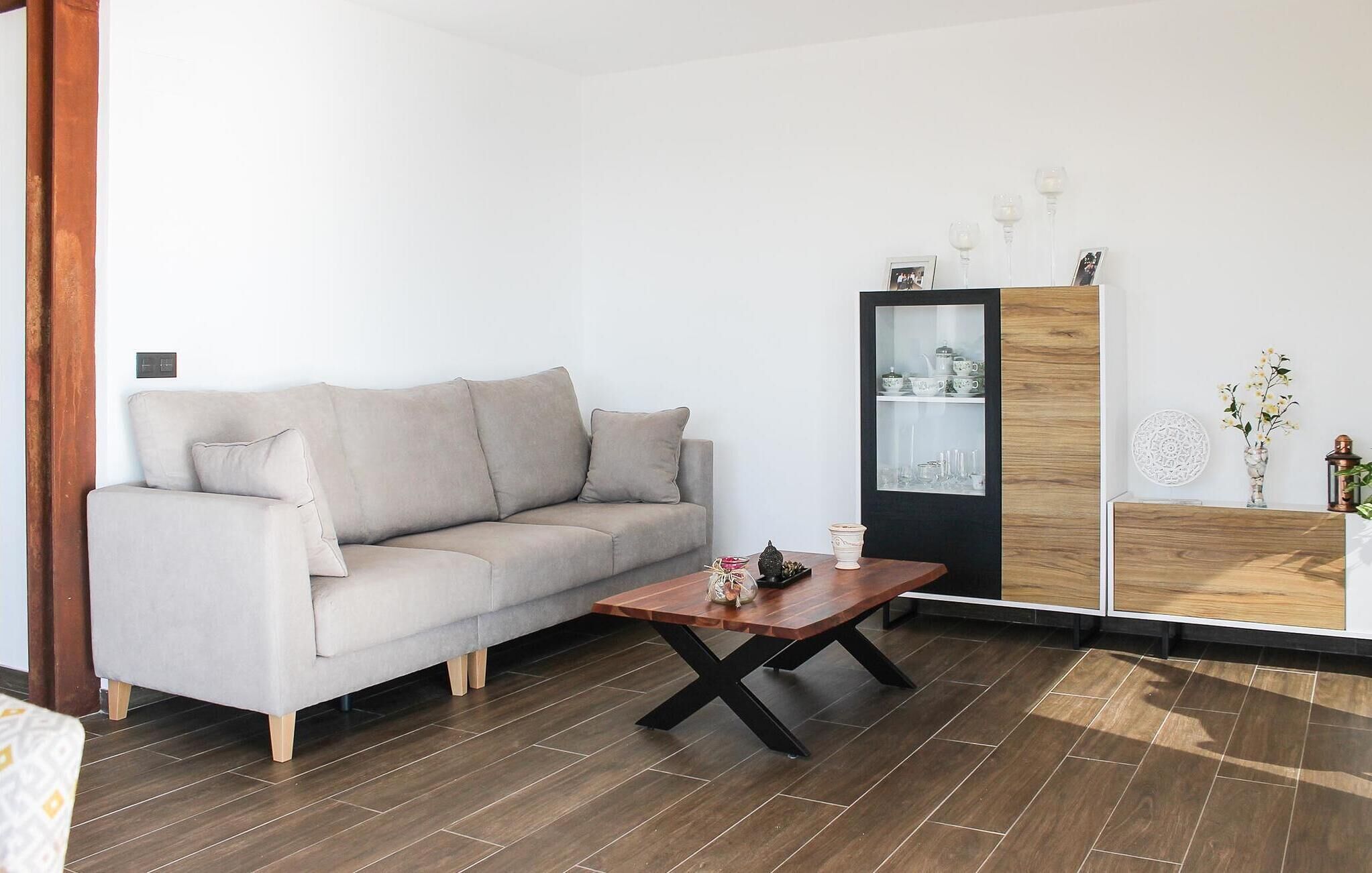 Un salon comprenant un canapé, une table basse et un meuble avec des portes en verre.