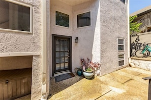 Enjoy a peaceful retreat in this charming outdoor space with a door, window, and potted plants.