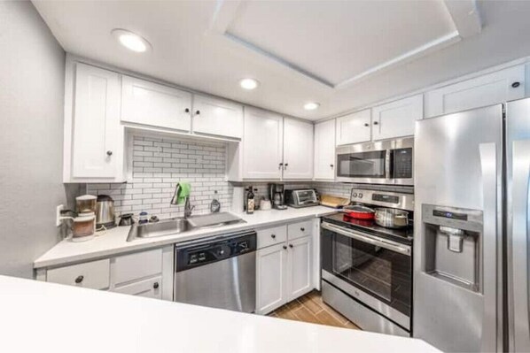 Enjoy cooking in this well-equipped kitchen with a dishwasher, oven, microwave, and refrigerator.