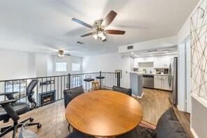 Relax in a spacious living area with a round dining table and comfortable seating, surrounded by a balcony with outdoor space.