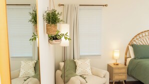 Un dormitorio acogedor con cama, mesita de noche y dos sillas.