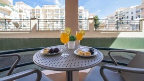 A table with a meal and drinks on a balcony overlooking a residential area. - Sunny Beach Treasure by Interhome (Armação de Pêra)