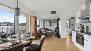 Eine moderne Küche mit Essbereich, großen Fenstern und Blick auf die Stadt.