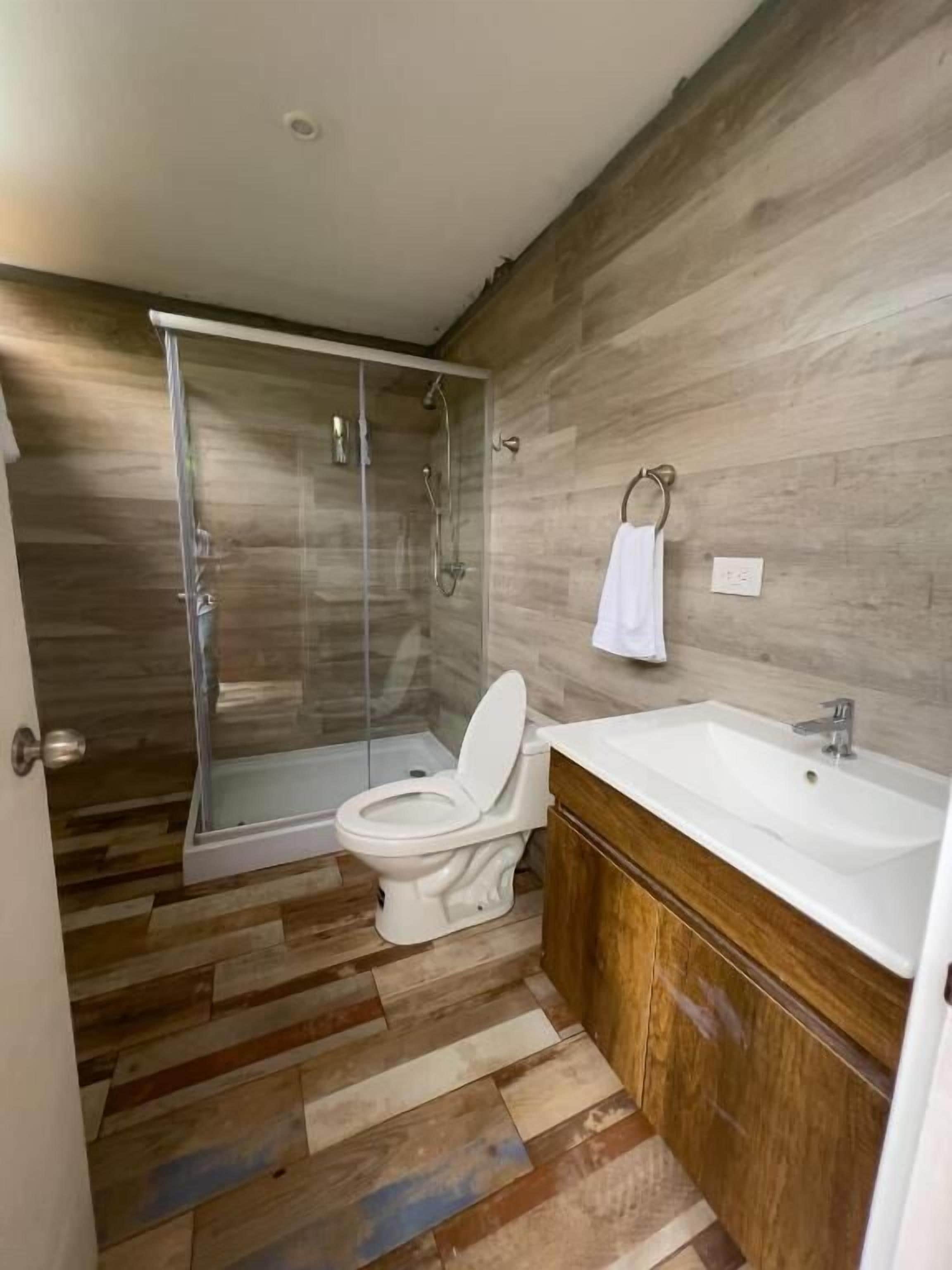Une salle de bain moderne équipée d’une douche, de toilettes et d’un lavabo.