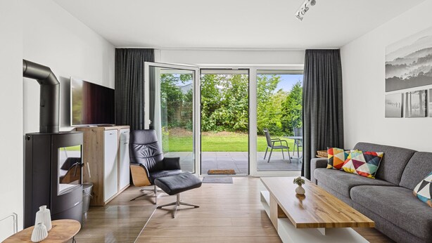 Ein modernes Wohnzimmer mit Kamin, einer Couch, einem Couchtisch und einem Fernseher.