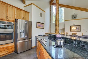 A modern kitchen with stainless steel appliances, wooden cabinets, and a granite countertop. - Hot Tub & Ski Shuttle: Rustic Breckenridge Retreat (Breckenridge)