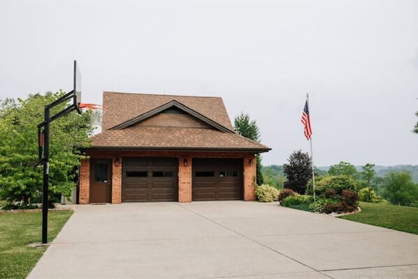A single-story brick building with a gabled roof, a front garage door, and an American flag.