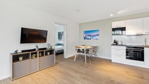 A modern apartment with a living room, dining area, and kitchen.