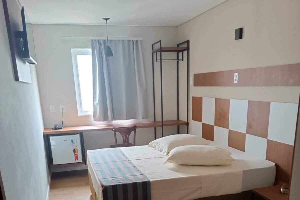 Un dormitorio con una cama, un escritorio y una silla.