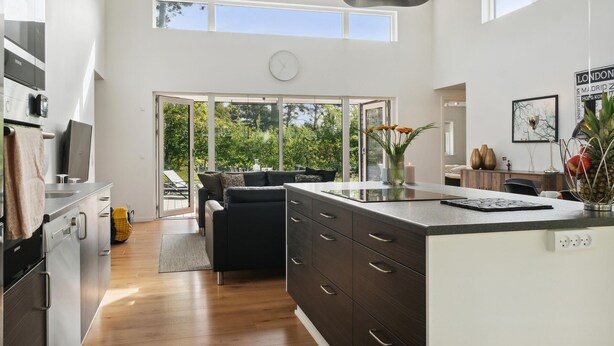 A modern kitchen with a large island, dark cabinetry, and a view of the outdoors. - Awesome home in Væggerløse with kitchen (Væggerløse)