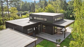 A modern two-story house with a flat roof, large windows, and a deck. - Awesome home in Væggerløse with kitchen (Væggerløse)