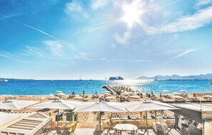 A beachside restaurant with outdoor seating overlooking the sea, a pier, and boats in the background. - 1 bedroom awesome apartment in Cannes (Cannes)